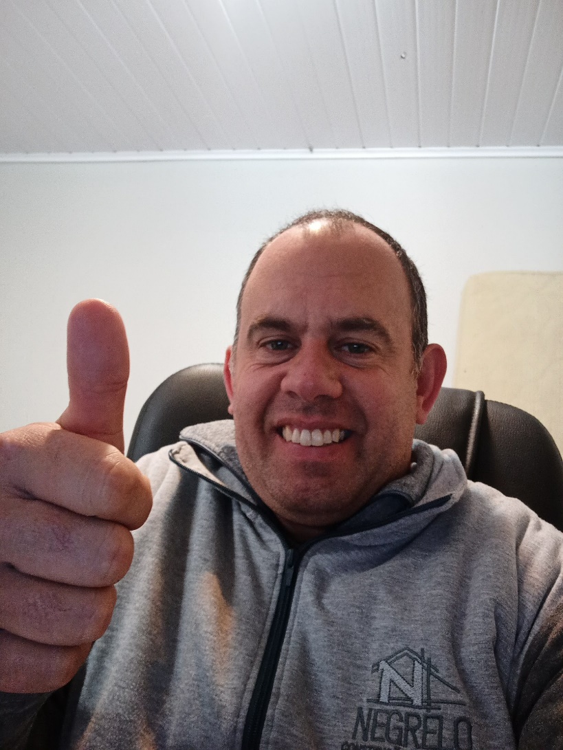 Emanuel em uma das primeiras fotos da fase inicial da empresa, sorrindo e fazendo sinal positivo.