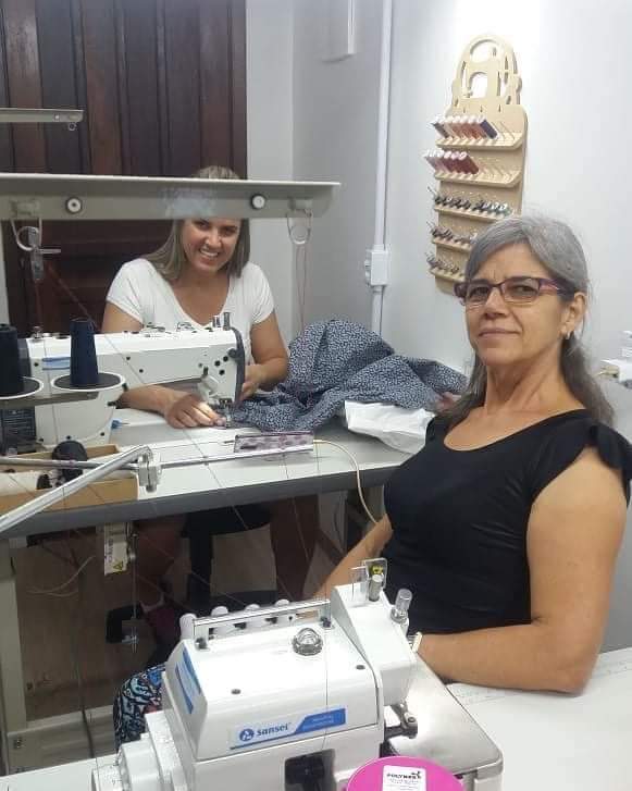 Merielin e colaboradora trabalhando em ateliê de costura, fase inicial de apoio à operação da NGL.
